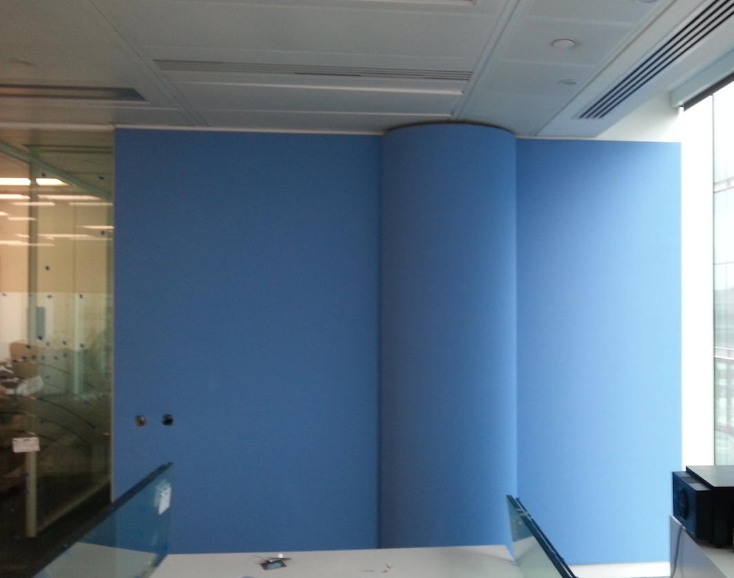 Blue fabric acoustic wall panels integrated around a curved commercial interior