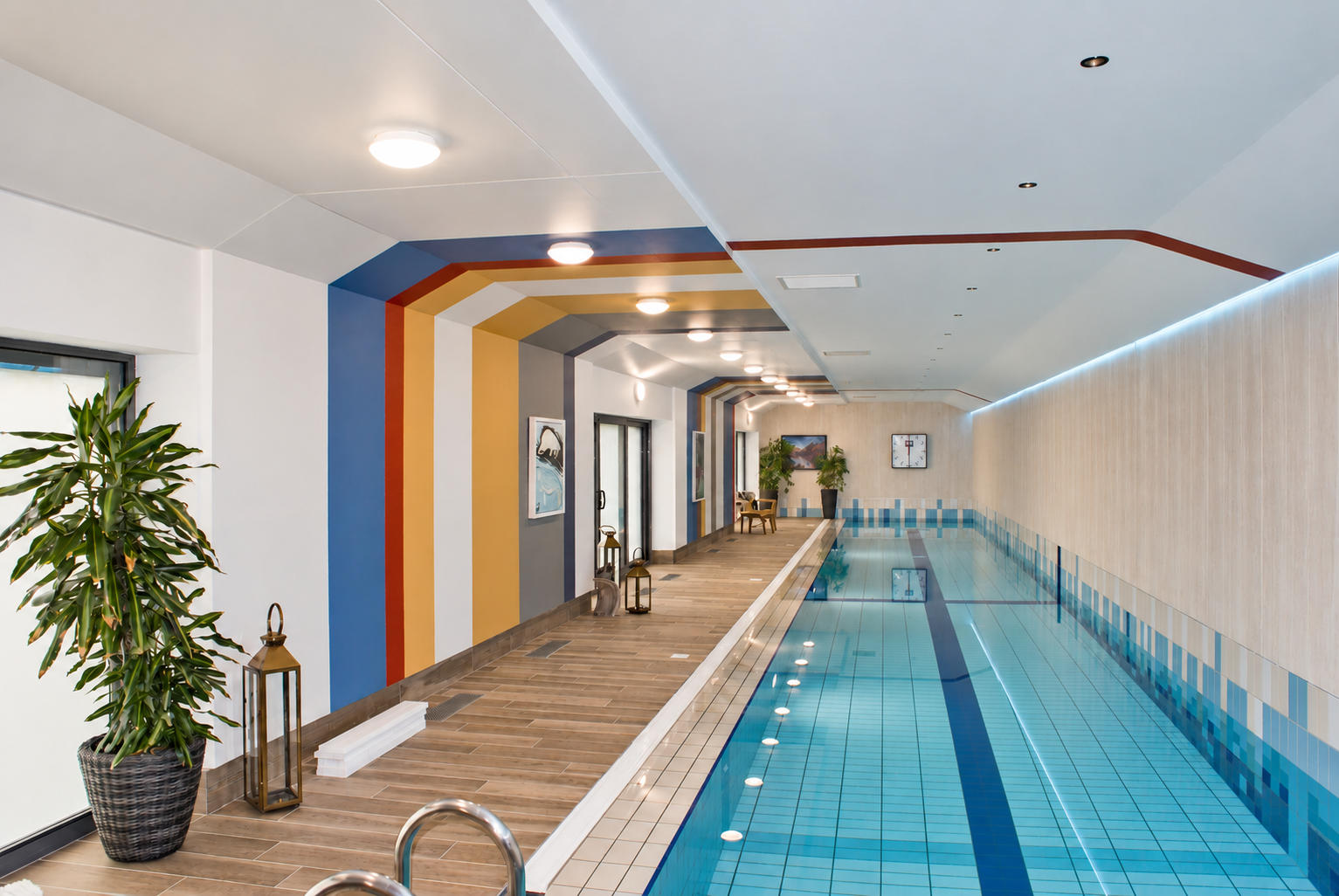 Indoor pool area with colorful walls, potted plants, and lanterns