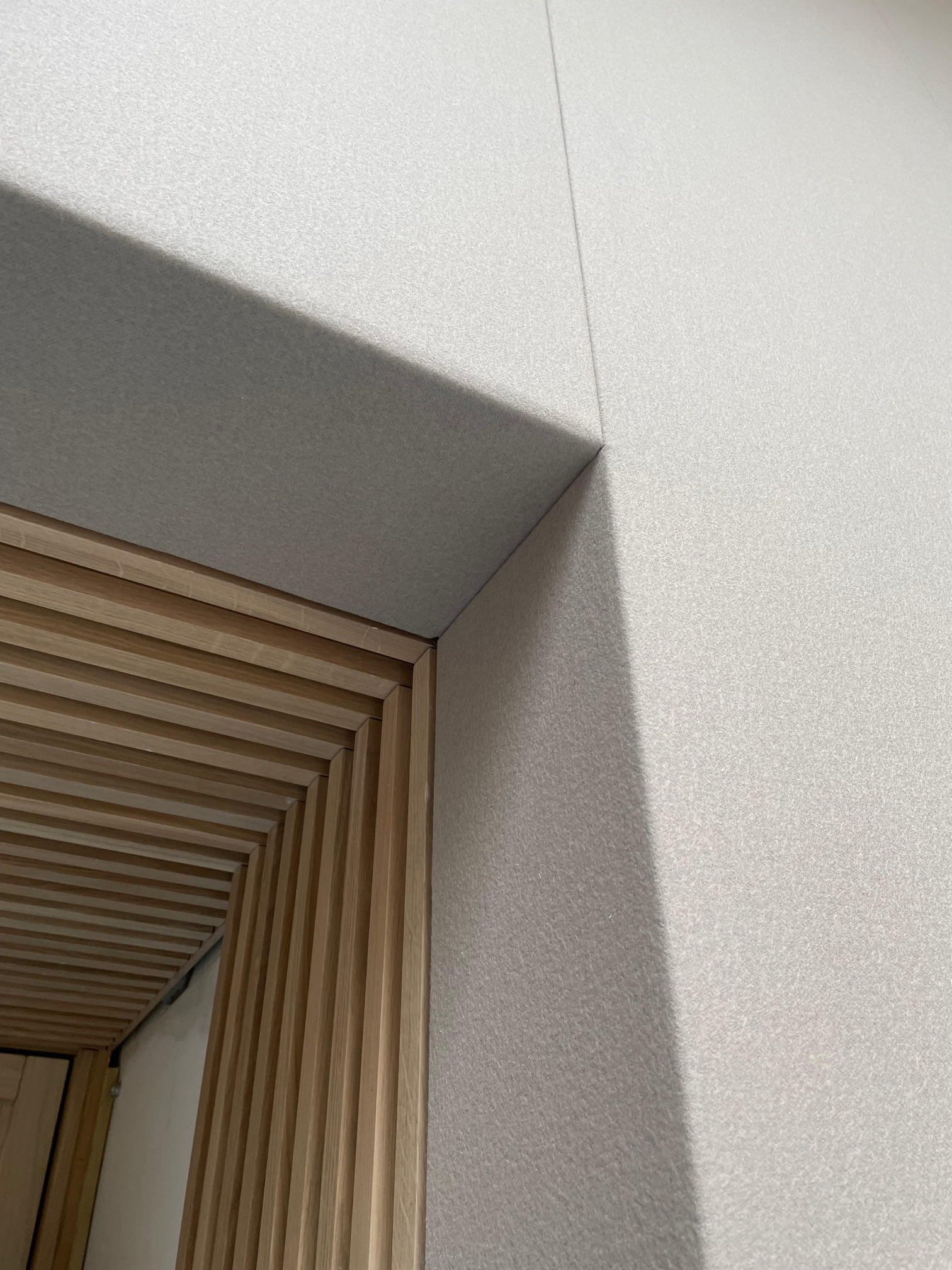 Specialist assessing an acoustic wall treatment installed in a studio setting