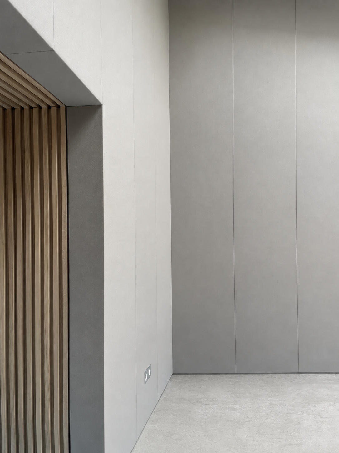 Minimalist interior design featuring smooth grey walls and wooden accents
