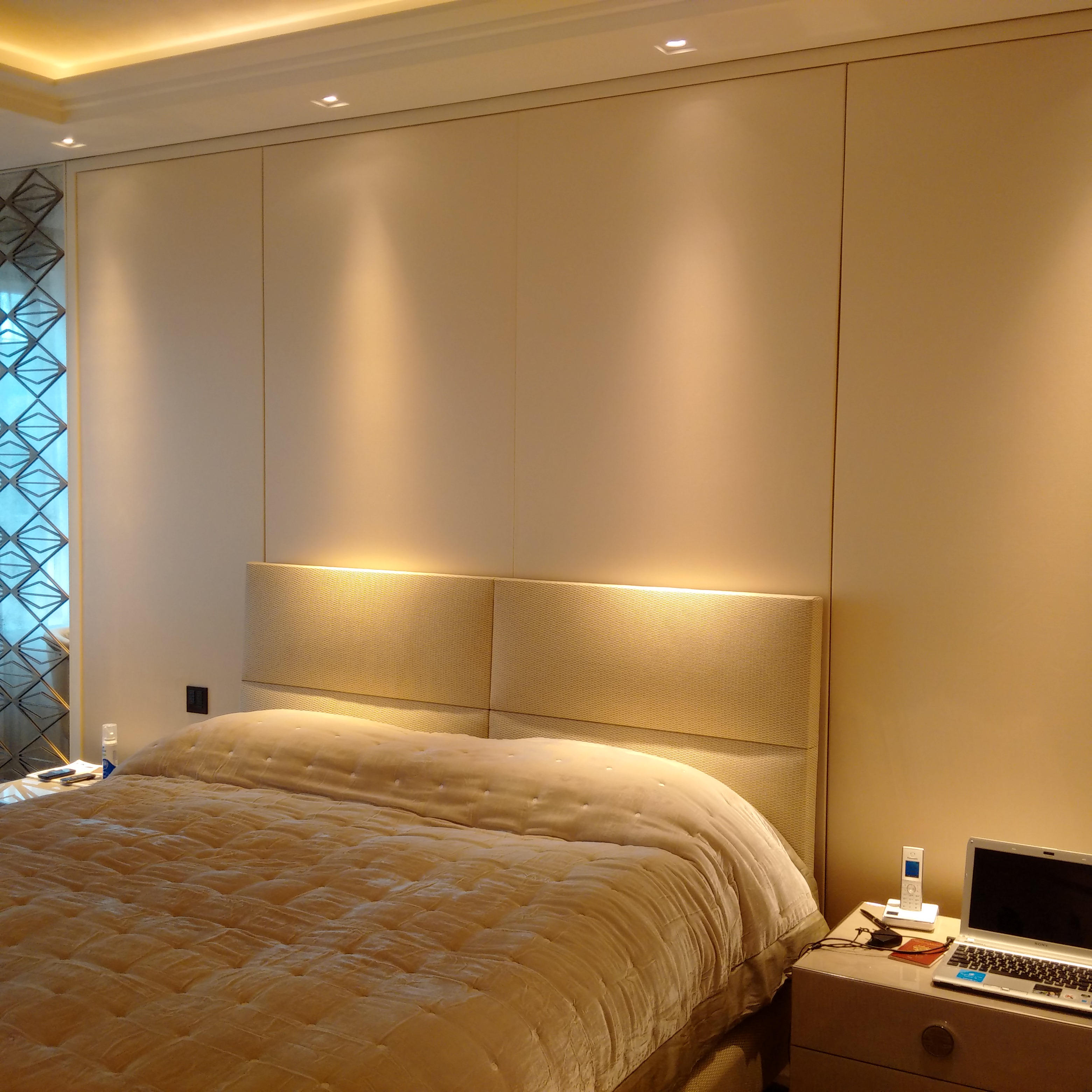 Fabric acoustic wall panels installed behind a bed in a residential interior